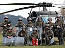 Soldaten der Einheit vor einem S-70 "Black Hawk" Hubschrauber.