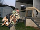 Ein Militärhundeführer macht sich und sein Tier bereit zum Abseilen.