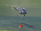 Während dieser Alouette-Helikopter Wasser aufnimmt, um das Feuer aus der Luft zu bekämpfen...