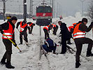 Soldaten befreien Bahnhof von Schnee.