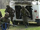 Soldaten booten von einem Radpanzer aus