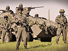 Soldaten vor einem Radpanzer Pandur