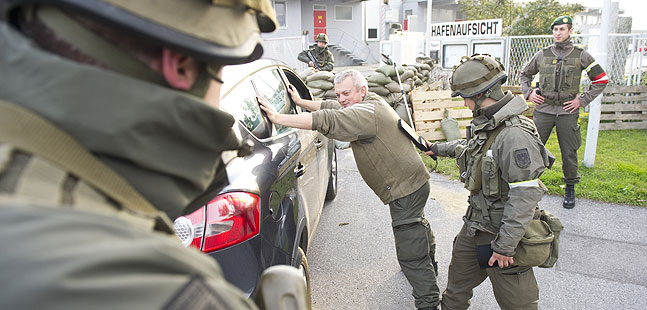 Soldaten kontrollieren den Fahrer eines Fahrzeuges.