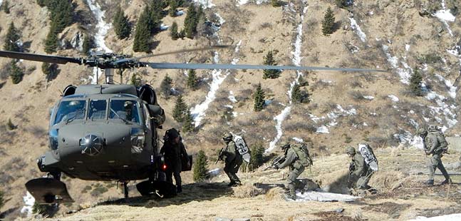 Ein Hubschrauber nimmt im Gebirge Soldaten auf.