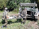 2 Sanitäter bringen einen verwundeten Kameraden in den Schützenpanzer. (Bild öffnet sich in einem neuen Fenster)