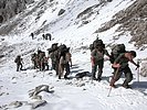 Die Männer und Frauen marschieren durch Schnee und über Eis. (Bild öffnet sich in einem neuen Fenster)