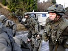 Im Schutz der Panzerfahrzeuge wird der Verwundete abtransportiert. (Bild öffnet sich in einem neuen Fenster)