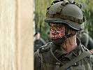 Ein Soldat wird im Gesicht - geschminkt - verletzt. (Bild öffnet sich in einem neuen Fenster)