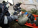 Behutsam wird der Patient geborgen, aus dem Gefahrenbereich getragen ... (Bild öffnet sich in einem neuen Fenster)