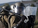 In voller Schutzausrüstung gingen die Soldaten gegen Eindringlinge vor. (Bild öffnet sich in einem neuen Fenster)