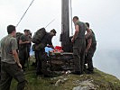 Als Krönung des Tages trägt sich diese Gruppe ins Gipfelbuch ein. (Bild öffnet sich in einem neuen Fenster)