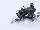 Ein Sondertransportfahrzeug Quad kämpft sich durch den Tiefschnee. (Bild öffnet sich in einem neuen Fenster)