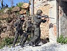 Panzergrenadiere gehen in einer Ortschaft vor. (Bild öffnet sich in einem neuen Fenster)