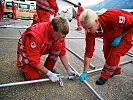 Rot-K-reuz-Helfer bauen ein Katastrophenzelt auf.