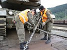 Zwei Soldaten lösen die Befestigungsketten eines Kampfpanzers. (Bild öffnet sich in einem neuen Fenster)