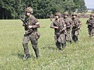 Verdächtige Personen flüchten in ein Waldstück. (Bild öffnet sich in einem neuen Fenster)