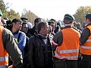 Einsatzkräfte bei einer Diskussion mit Flüchtlingen. (Bild öffnet sich in einem neuen Fenster)