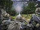 Österreichische Gebirgssoldaten im scharfen Schuss auf einen Gegenhang.