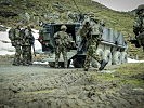 Schweizer Soldaten beim Aufsitzen auf einen Radpanzer. (Bild öffnet sich in einem neuen Fenster)