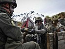 Eine Gruppe nützt eine Feuerpause, um Munition zu verteilen. (Bild öffnet sich in einem neuen Fenster)