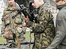 Ein Schweizer Soldat begutachtet ein belgisches Scharfschützengewehr. (Bild öffnet sich in einem neuen Fenster)