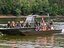 Das Flüchtlingsboot wird an das sicher Ufer geleitet. (Bild öffnet sich in einem neuen Fenster)