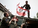 Die österreichische Flagge wird auf einen Container gesetzt. (Bild öffnet sich in einem neuen Fenster)