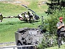 Ein Radpanzer "Pandur" sichert einen gelandeten "Kiowa"-Hubschrauber. (Bild öffnet sich in einem neuen Fenster)