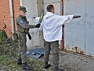 Eine Person wird mit einem Metalldetektor "Garrett" abgesucht. (Bild öffnet sich in einem neuen Fenster)