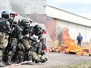 Die Soldaten schützen sich vor Wurfgeschossen. (Bild öffnet sich in einem neuen Fenster)