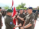 Der scheidende Kontingentskommandant, r., übergibt die Fahne. (Bild öffnet sich in einem neuen Fenster)