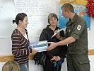 Eine Lehrerin der Grundschule von Cerska bekommt Schulhefte überreicht. (Bild öffnet sich in einem neuen Fenster)