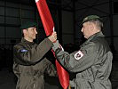 Oberst Jenschik, l., übernimmt die Flagge von Generalmajor Heidecker. (Bild öffnet sich in einem neuen Fenster)