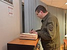 Generalmajor Trauner trägt sich in das Gästebuch des Kontingents ein. (Bild öffnet sich in einem neuen Fenster)