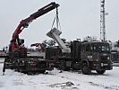 Ein Schweizer Kran lädt eine "T-Wall" auf einen österreichischen LKW. (Bild öffnet sich in einem neuen Fenster)