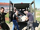 Die Schüler und CIMIC-Soldaten laden einen Strom-Stabilisator aus. (Bild öffnet sich in einem neuen Fenster)