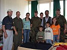 Vizeleutnant Gabelar, 2.v.l., mit einer bedürftigen Familie. (Bild öffnet sich in einem neuen Fenster)