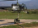 Feuerwehrmänner befüllen den Löschbehälter einer Bell UH-1D. (Bild öffnet sich in einem neuen Fenster)