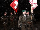 Die Soldaten marschieren mit den Fahnen Österreichs und der Schweiz ein. (Bild öffnet sich in einem neuen Fenster)