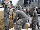 Die Soldaten befüllen die Sandsäcke. (Bild öffnet sich in einem neuen Fenster)