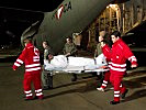 One of the wounded soldiers is carried out of the C-130. (Image opens in new window)