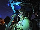 A helicopter pilot gets ready for a night sortie.