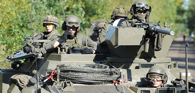 Soldaten auf einem Radpanzer.