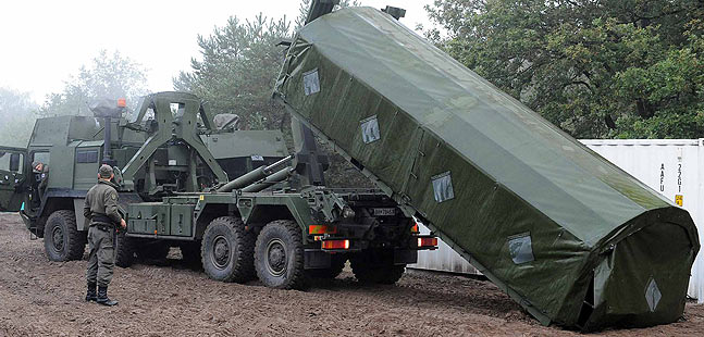 Ein Hakenladesystem lädt einen Container ab.