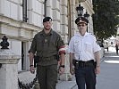 Soldat und Polizist bewachen gemeinsam eine Botschaft.