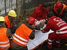 Der verletzte Soldat wird zum Abtransport auf die Bergetrage gelegt. (Bild öffnet sich in einem neuen Fenster)