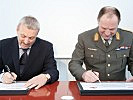Zeiler und Raffetseder unterzeichnen die Partnerschaftsurkunde.
