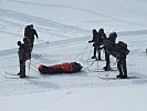 Abtransport eines Geborgenen durch Soldaten nach einem Lawineneinsatz.