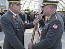 Generalleutnant Höfler, r., übergab die Fahne und damit das Kommando an Brigadier Hufler.