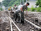 In Salzburg befreien die Helfer den Bahnhof Taxenbach vom Schlamm.